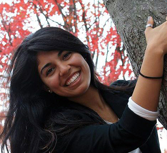 Une femme se tient les bras croisés à côté d’une fenêtre